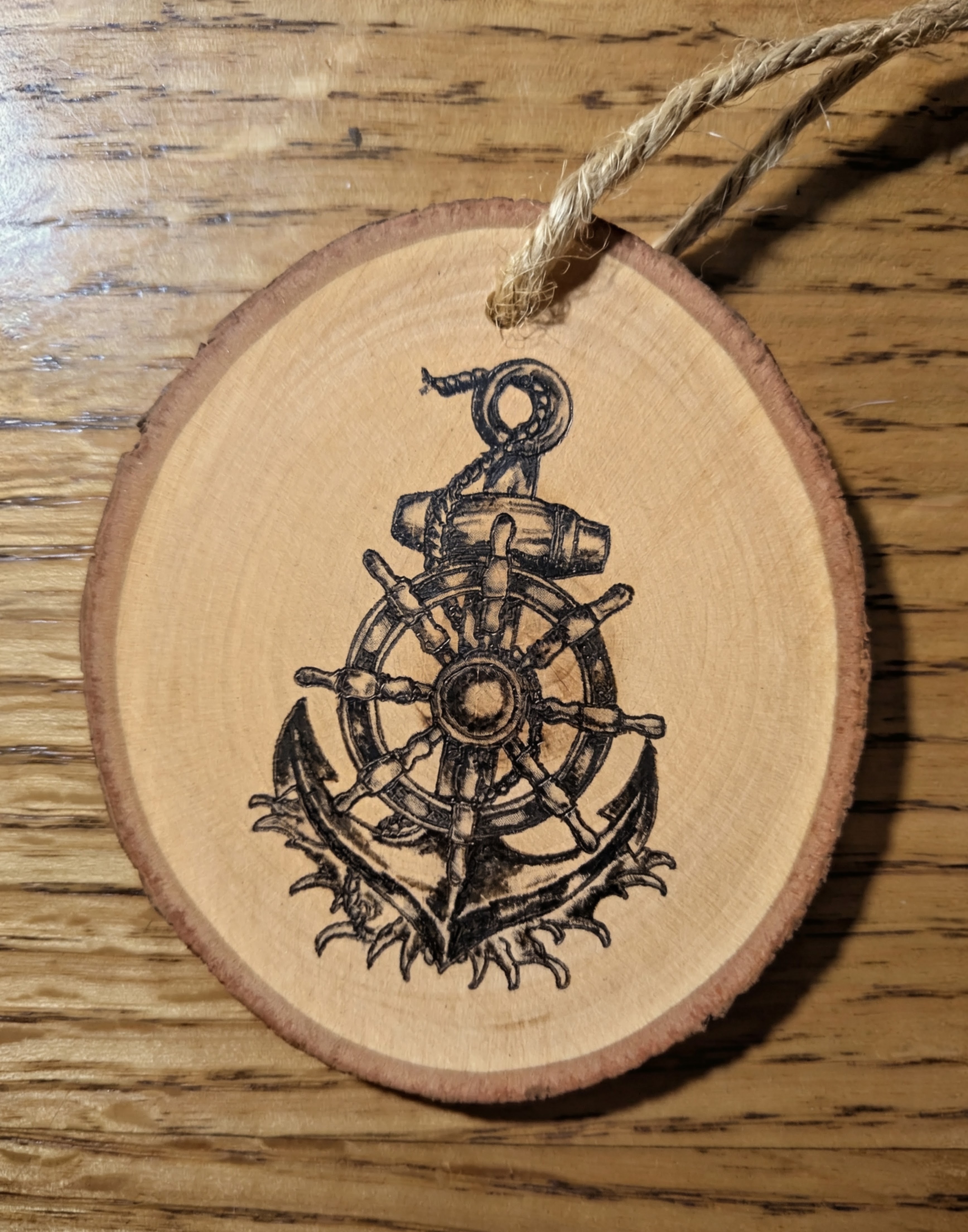 Wood slice ornament with a hand burned anchor and ship helm